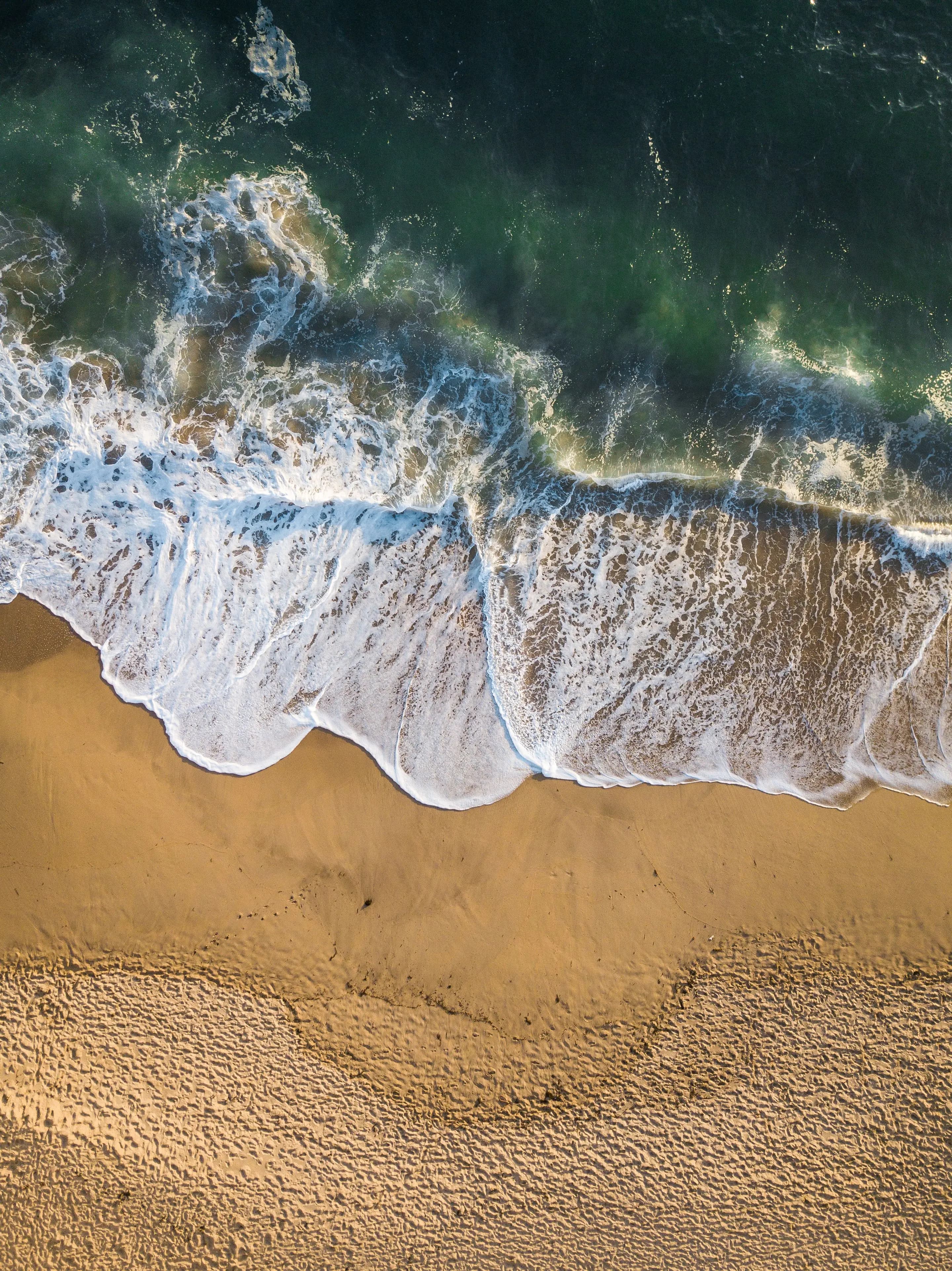 Surf washing onto the sand, seen from directly above